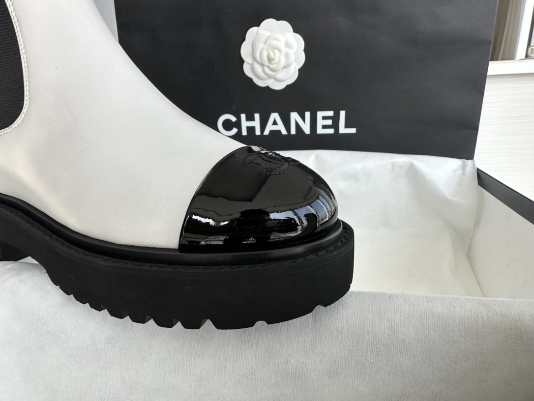 Chanel 22c Chunky Black and White Spliced Slip-On Short Boots: Featuring Rich Texture Inside and Out, with Delicate Sheepskin and Glossy Patent Leather. Exuding Understated Sophistication