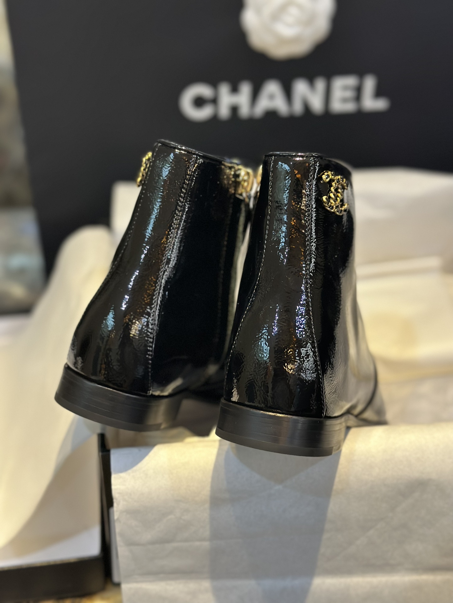 Chanel 23a Crinkled Patent Leather Chelsea Boots: A pair of understated yet exquisitely crafted ankle boots. Featuring sleek black patent leather with subtle gloss, minimalist design with only a brand logo decoration on the vamp. The interior is lined wit