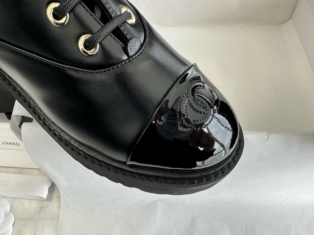 Chanel 23C Black Lace-Up Martin Boots: Crafted with sleek calfskin and patent leather