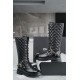 Chanel  23b  Chain Long Martin Boots: Crafted from black oil leather and black patent leather, with a leather combination sole. Classic diamond-pattern stitching and chain elements intertwine on the vamp