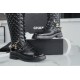 Chanel  23b  Chain Long Martin Boots: Crafted from black oil leather and black patent leather, with a leather combination sole. Classic diamond-pattern stitching and chain elements intertwine on the vamp