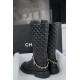 Chanel  23b  Chain Long Martin Boots: Crafted from black oil leather and black patent leather, with a leather combination sole. Classic diamond-pattern stitching and chain elements intertwine on the vamp