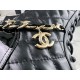 Chanel  23b  Chain Long Martin Boots: Crafted from black oil leather and black patent leather, with a leather combination sole. Classic diamond-pattern stitching and chain elements intertwine on the vamp