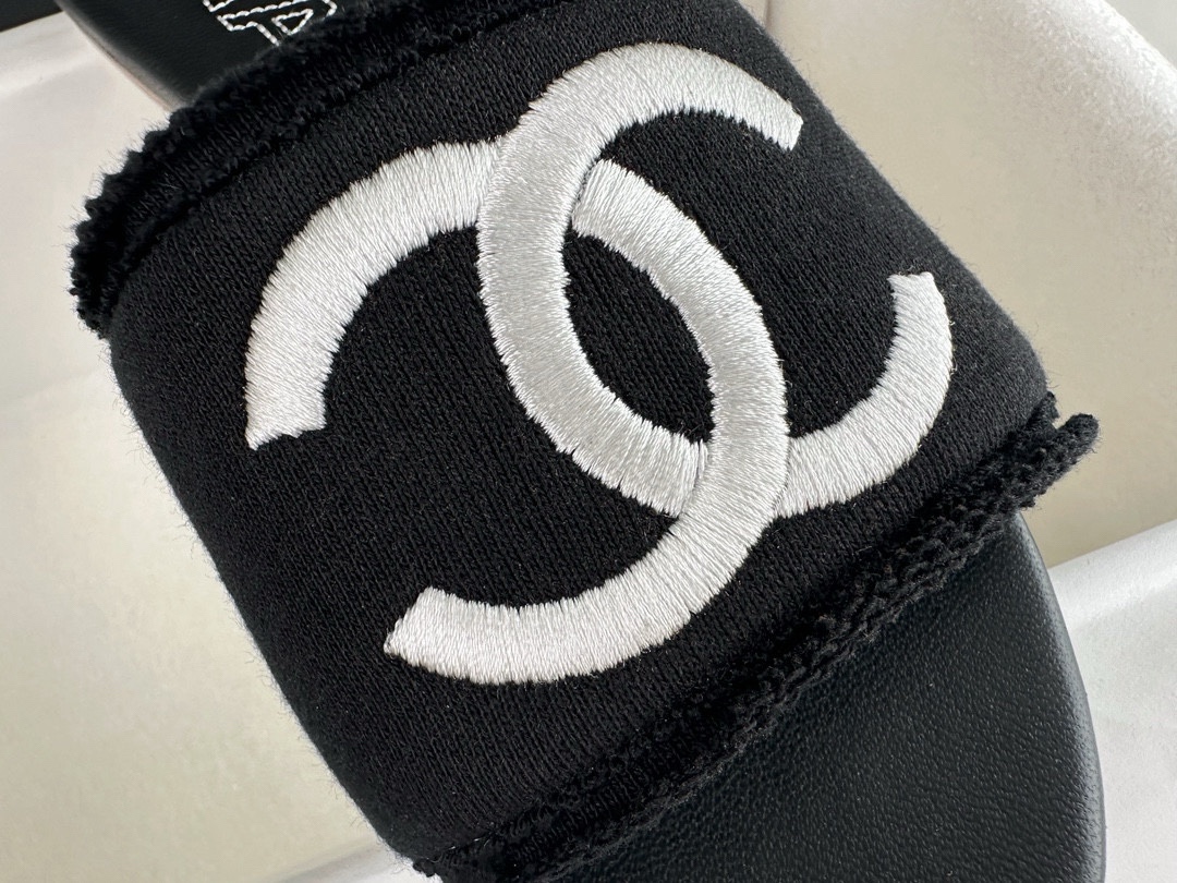 Chanel Black Double C Embroidered Slides: Featuring a Striking Black and White Color Block Design on the Upper, Karen Satin Fabric with Imported Thread Embroidery, Finished with a White Leather Sole. 